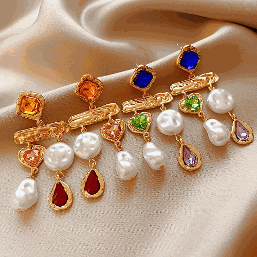 Rhinestone asymmetrical pearl earrings for women with colorful gemstones and gold accents on satin background