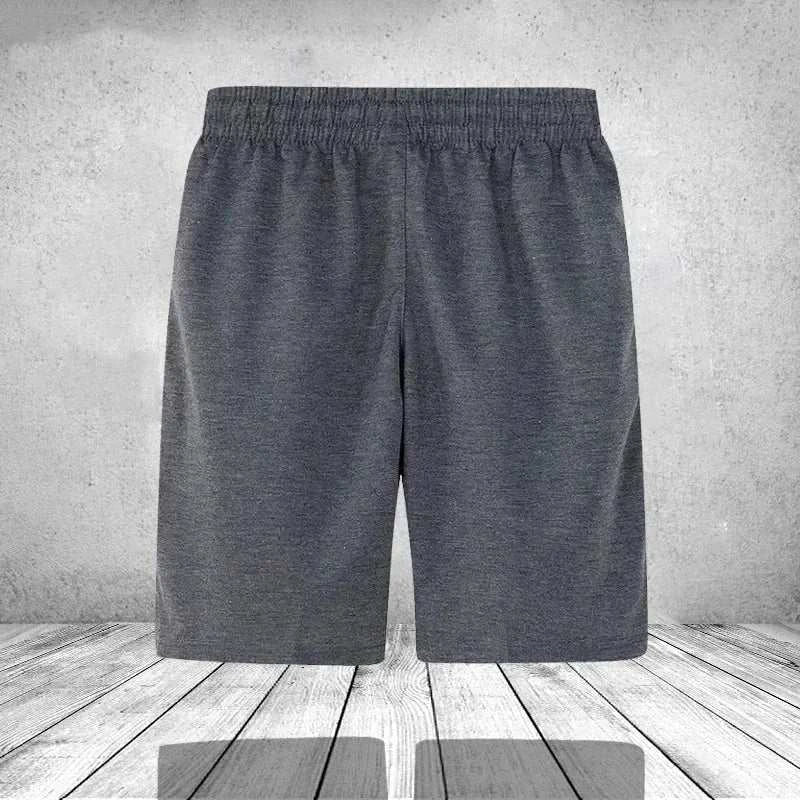 Men's gray summer casual beach shorts with elastic waistband on wooden floor background