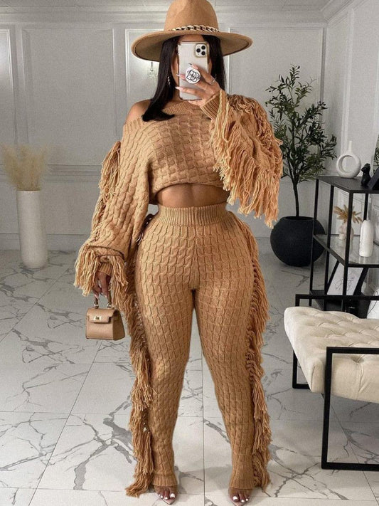 Two Pieces Women's winter warm knitted fringe sweater and pants set in beige with wide-brim hat and handbag in modern indoor setting