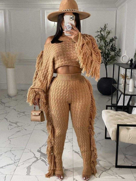 Two Pieces Women's winter warm knitted fringe sweater and pants set in beige with wide-brim hat and handbag in modern indoor setting