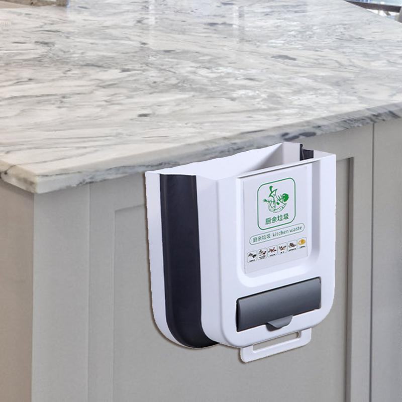 White wall-mounted folding trash can attached to kitchen cabinet for space-saving waste disposal