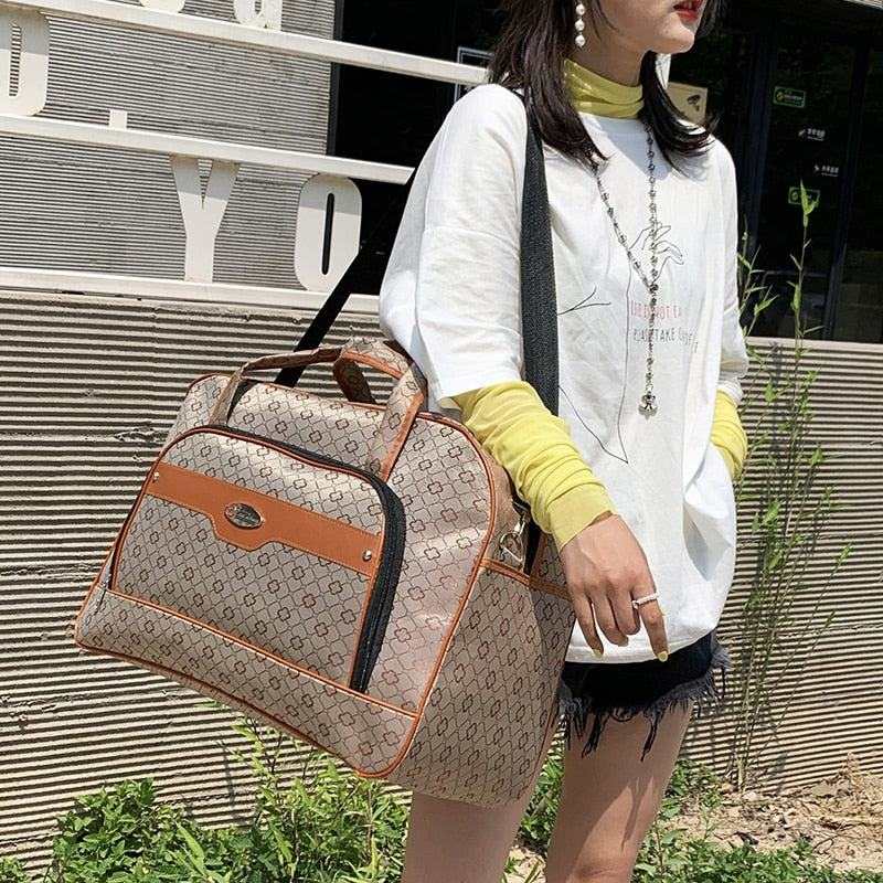 Stylish women's travel bag with shoulder strap and brown accents, perfect for multifunctional hand luggage use