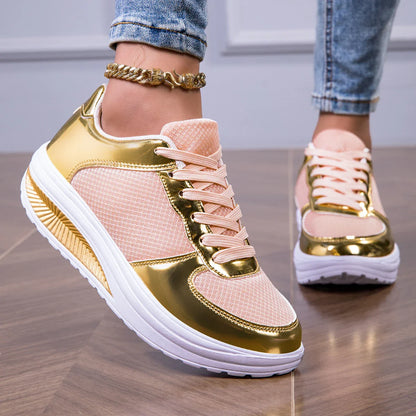 Women's walking shoes pink and gold sneakers with white sole worn with denim jeans on wooden floor