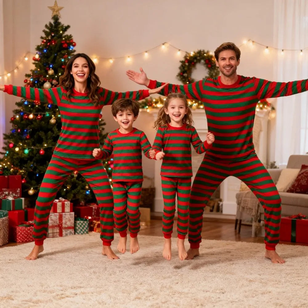 Family wearing matching red and green striped Christmas pajamas in a festive living room with decorated Christmas tree and gifts