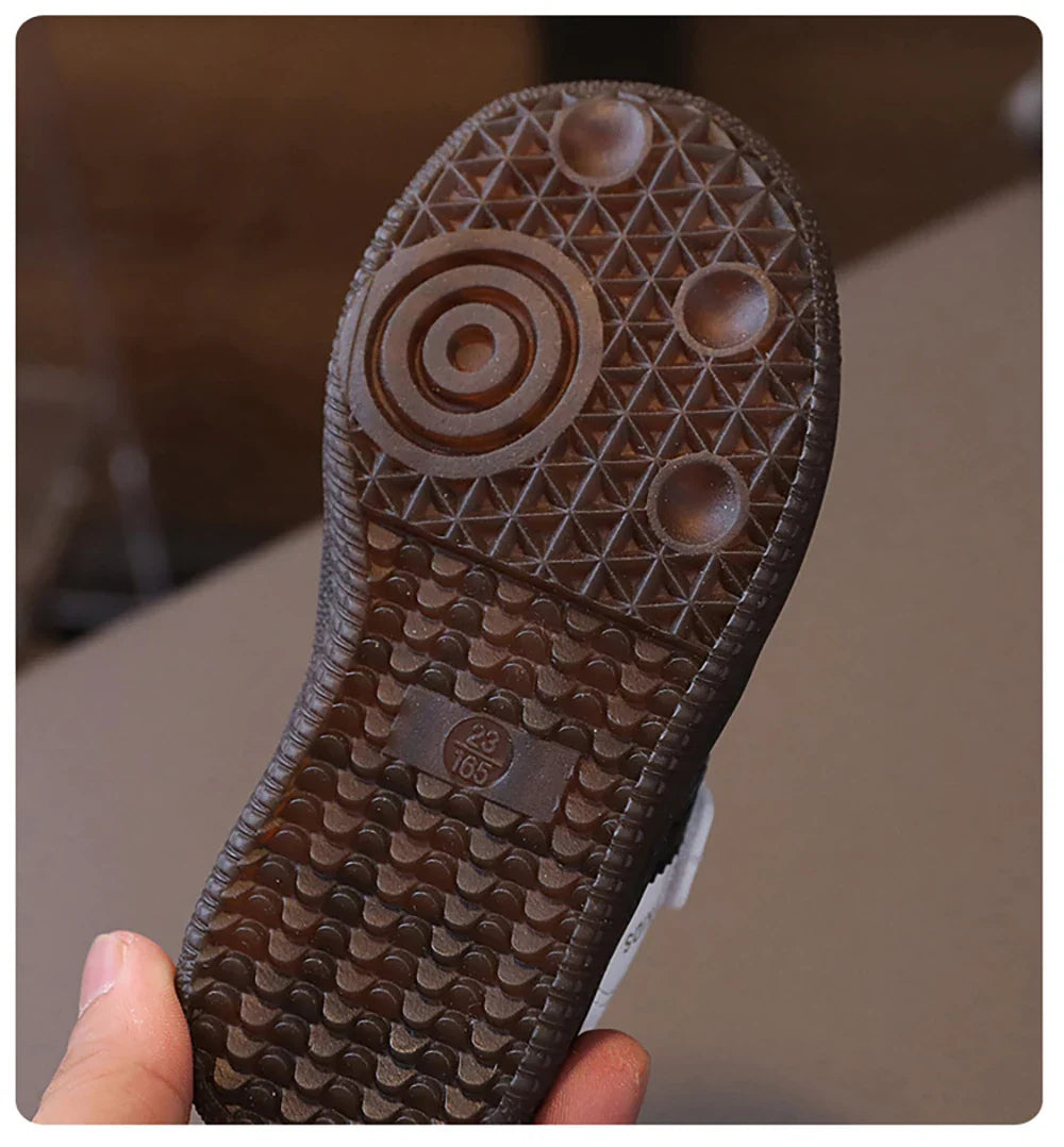 Close-up of the sole of unisex sneakers for kids showing tread pattern and size marking